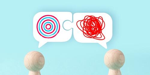 Wooden figures with speech bubbles showing squiggly and circular drawings